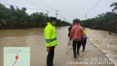 Respons Cepat Laporan Call Center 110, Polsek Padang Tualang Atur Lalu Lintas di Jalan Sumur Bor yang Tergenang Air